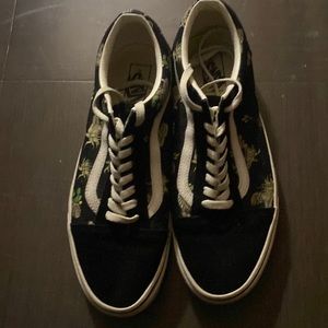 Black and green vans with snake and leaves design on it